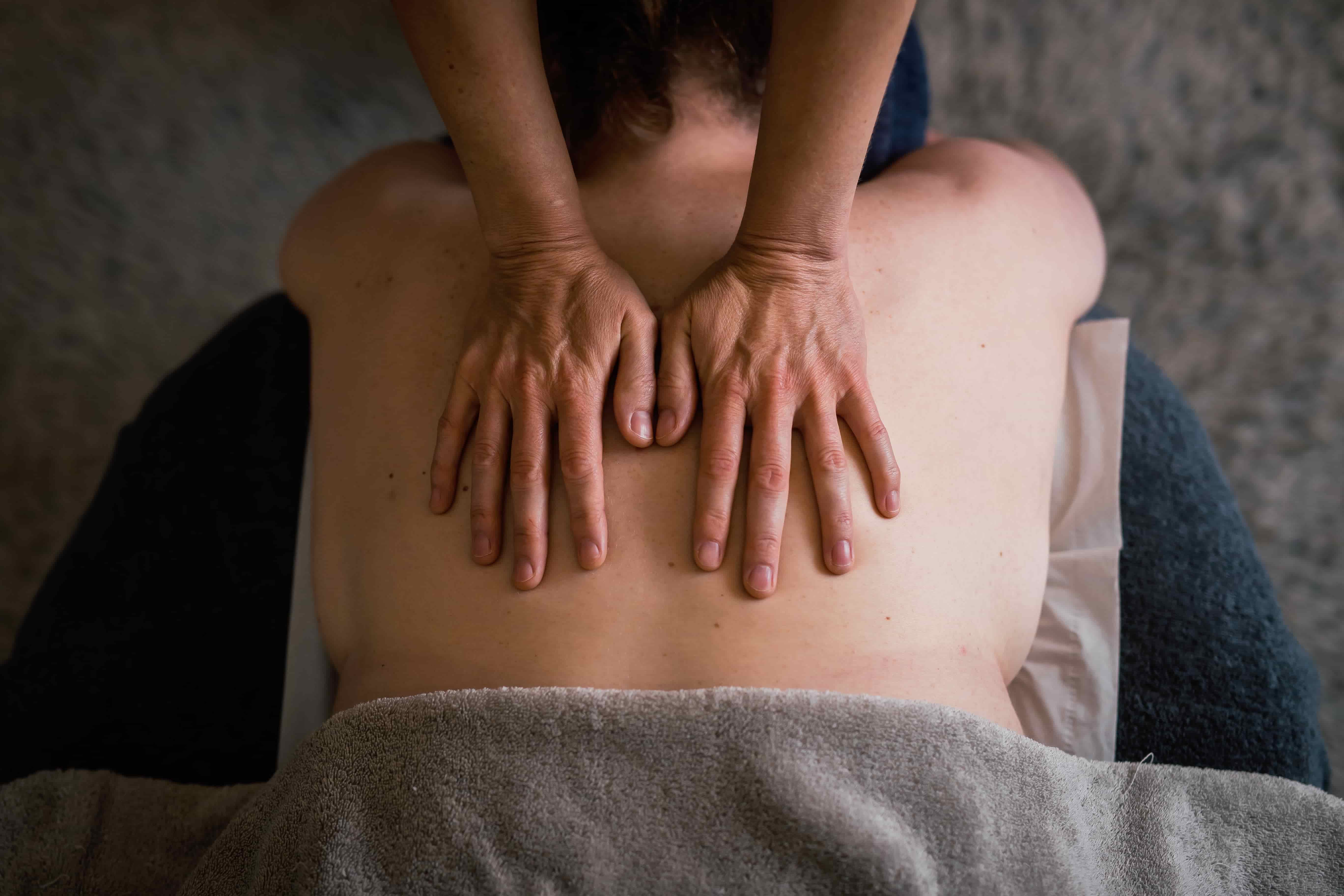 hands massaging a persons back